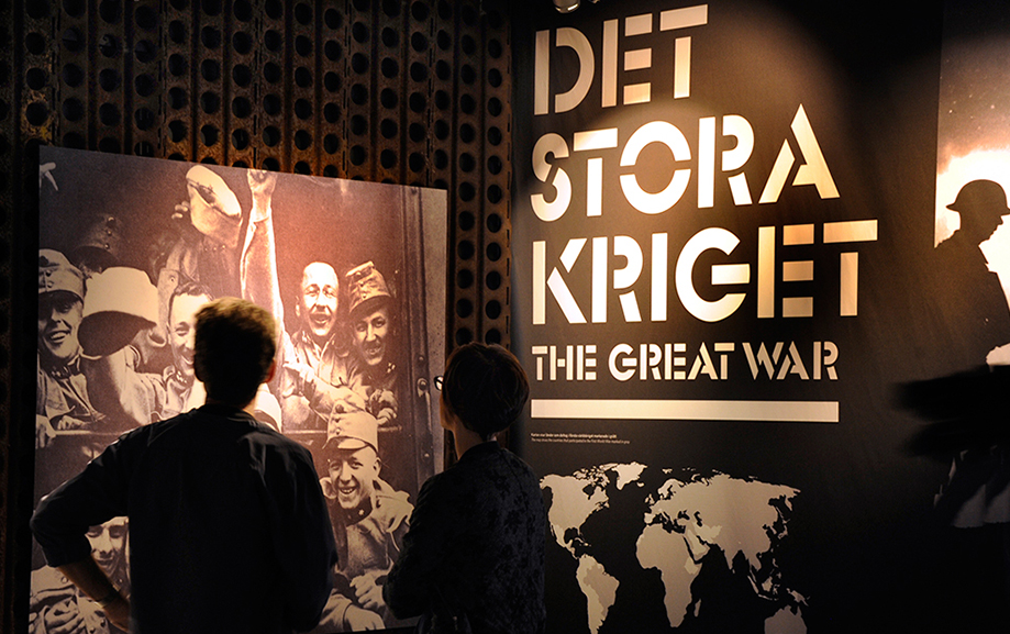 "Det stora kriget" st&aring;r i vitt mot svart v&auml;gg. Framf&ouml;r st&aring;r en bes&ouml;kare och kollar p&aring; svartvita bilder av m&auml;nniskor som upplevde kriget.