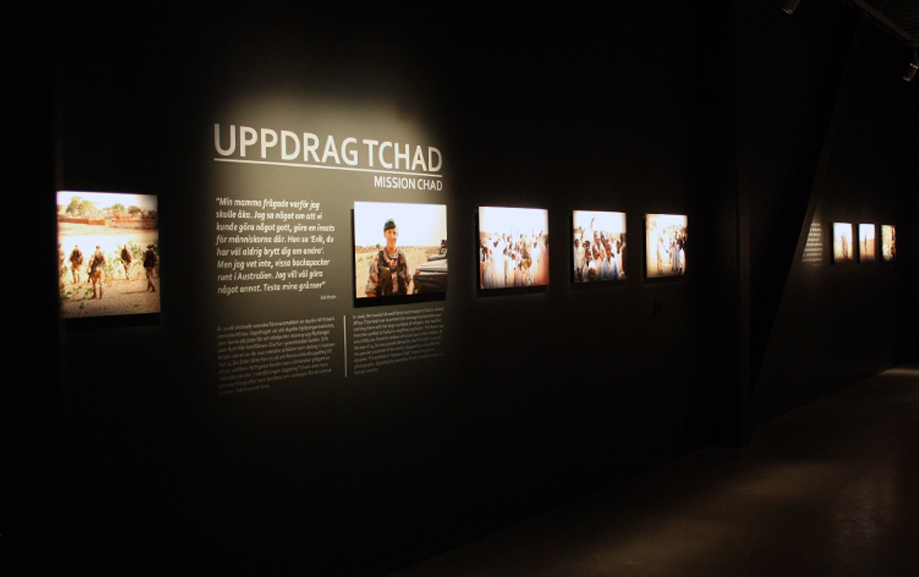Uppdrag Tchad st&aring;r det p&aring; den svarta v&auml;ggen som &auml;ven pryds av flera fotografier fr&aring;n utst&auml;llningen.