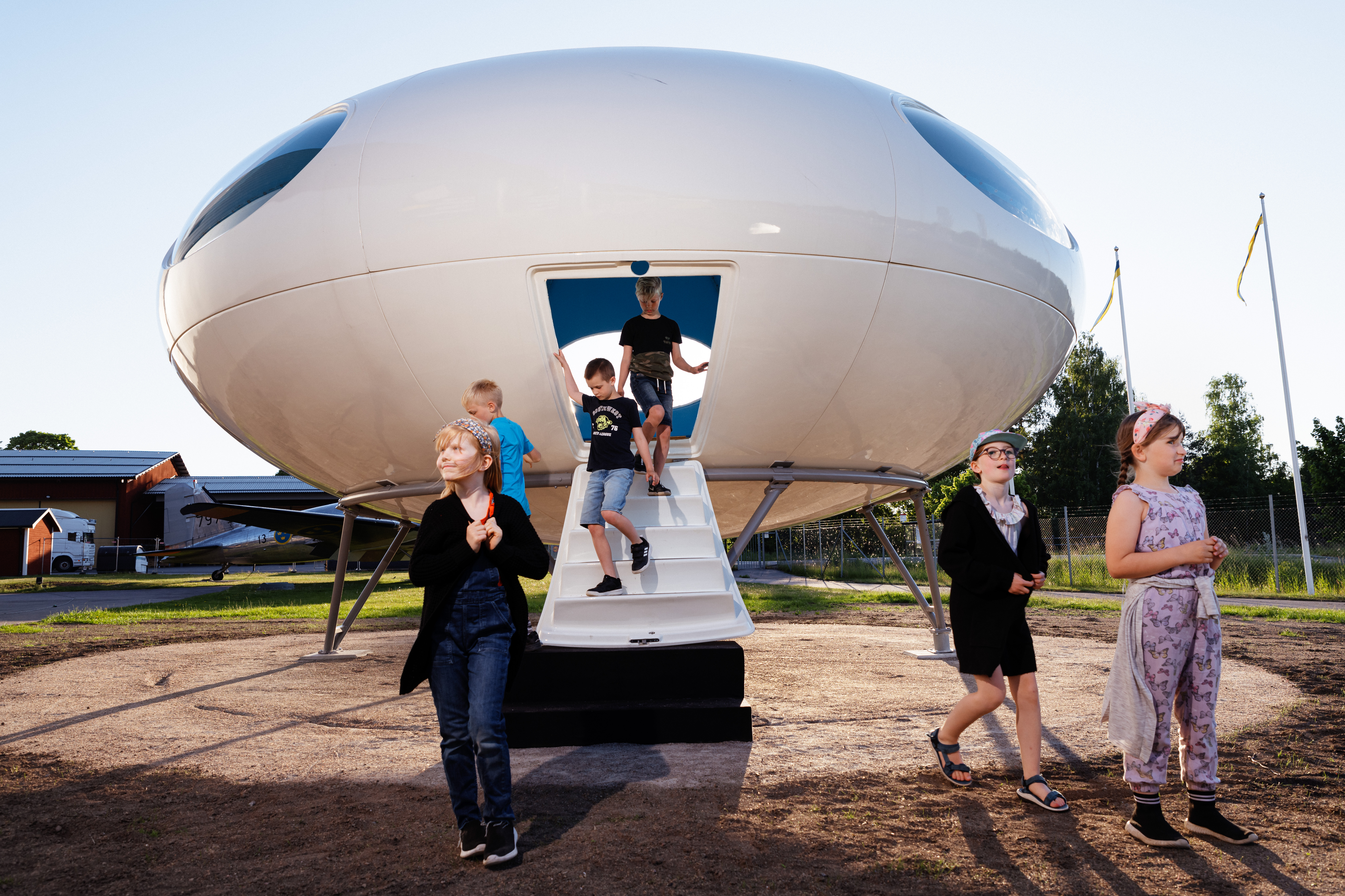 En grupp bes&ouml;kare kliver ut ur det ellipsformade vita lilla huset.