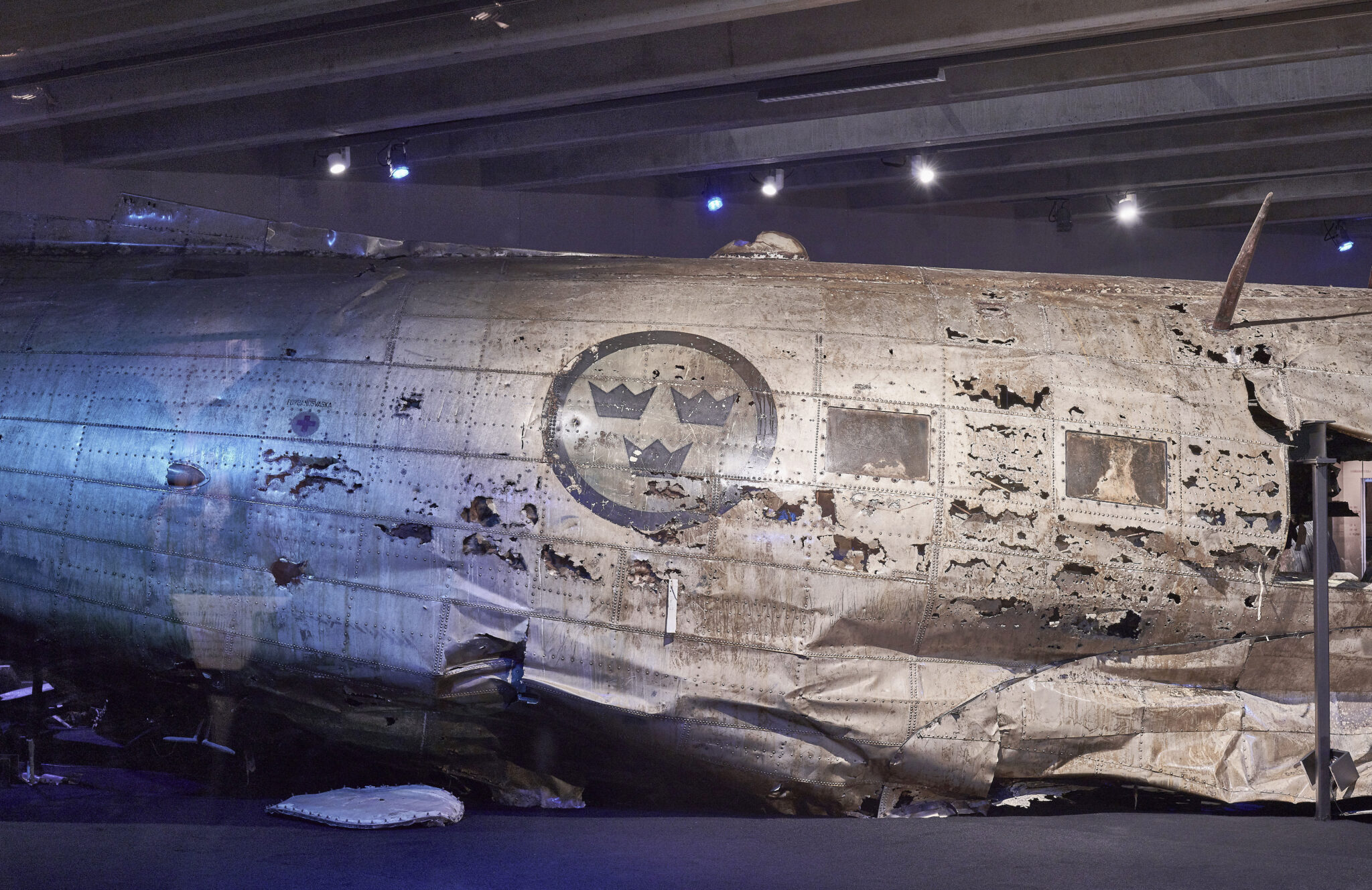 N&auml;rbild av en av de st&ouml;rre vrakdelarna efter den b&auml;rgade DC-3an med flygvapnets vapen med tre kronor p&aring; flygplanets sida.