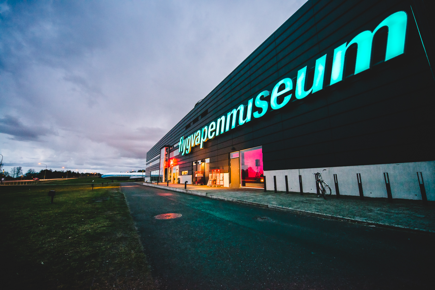 En exteriörbild av Flygvapenmuseums entré i kvällsljus.