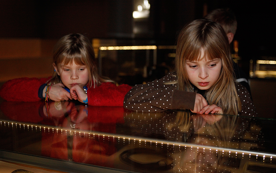 Tv&aring; barn tittar intresserat ner i en monter tillh&ouml;rande utst&auml;llningen om den b&auml;rgade DC3:an.