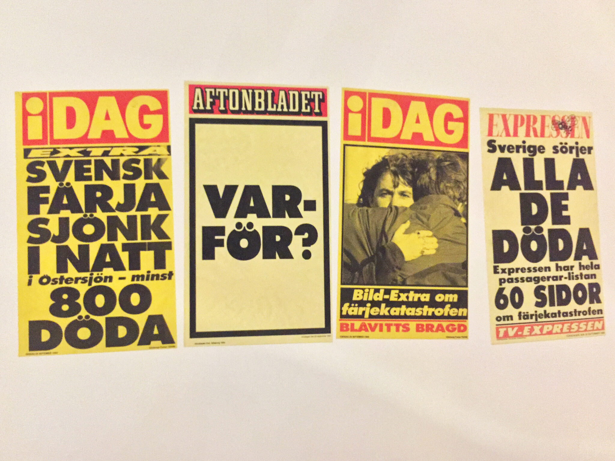 Fyra l&ouml;psedlar fr&aring;n svenska tidningar uppsatta bredvid varandra. De handlar om Estoniakatastrofen 1994, med rubriker som "Svensk f&auml;rja sj&ouml;nk i natt &ndash; minst 800 d&ouml;da", "VARF&Ouml;R?", "Bl&aring;vitts bragd" och "Sverige s&ouml;rjer alla de d&ouml;da". L&ouml;psedlarna har tydliga f&auml;rger i r&ouml;tt, gult och svart.