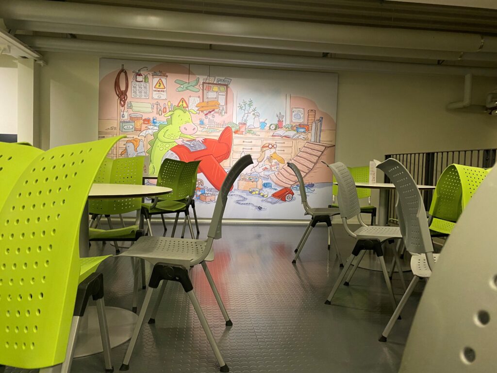 I Flyglabbet finns en matsäcksyta där du kan slå dig ner med egen matsäck. På ena väggen hänger en stor tavla med museets maskotar Drakel och Viggo i deras verkstad.