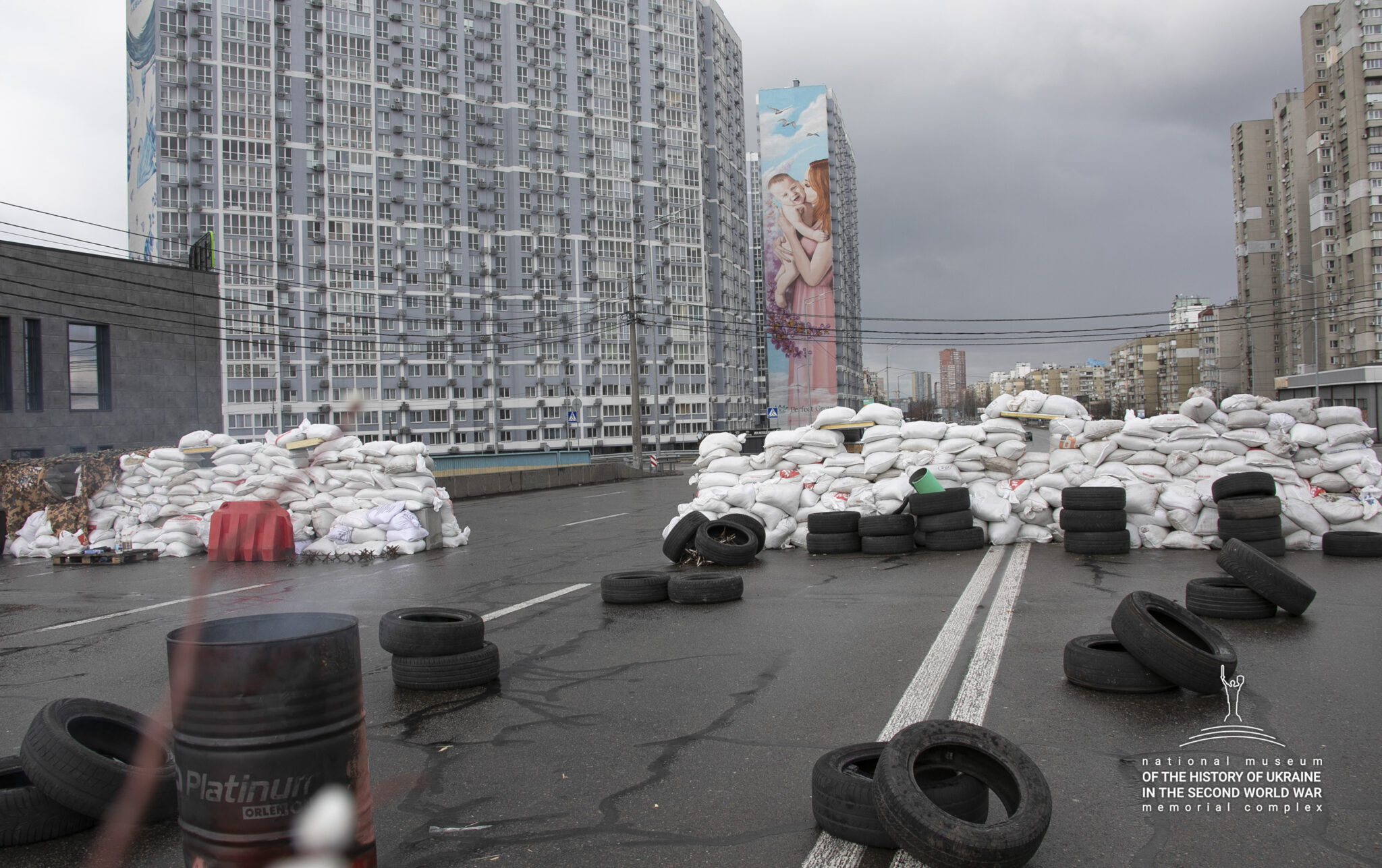 P&aring; en bilv&auml;g med h&ouml;ga byggnader l&auml;ngs sidorna har n&aring;gon byggt vallar av sands&auml;ckar och bild&auml;ck.