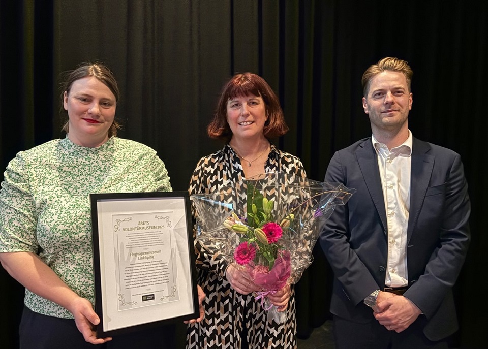 Tre personer, från vänster: Sofia Svalmark, som håller i ett diplom, Jenny Helsing, som håller i en bukett med blommor i rosa och grönt, samt Per Stålebro står uppställda bredvid varandra för bilden. 